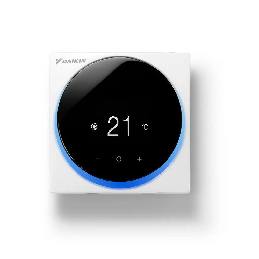 Weißer Raumthermostat von Daikin mit runder, schwarzer Displayfläche und blauer LED-Beleuchtung, zeigt Temperatur von 21 °C an. Bedienung über Plus- und Minus-Tasten.